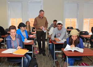 teacher walking through rows of students at desks