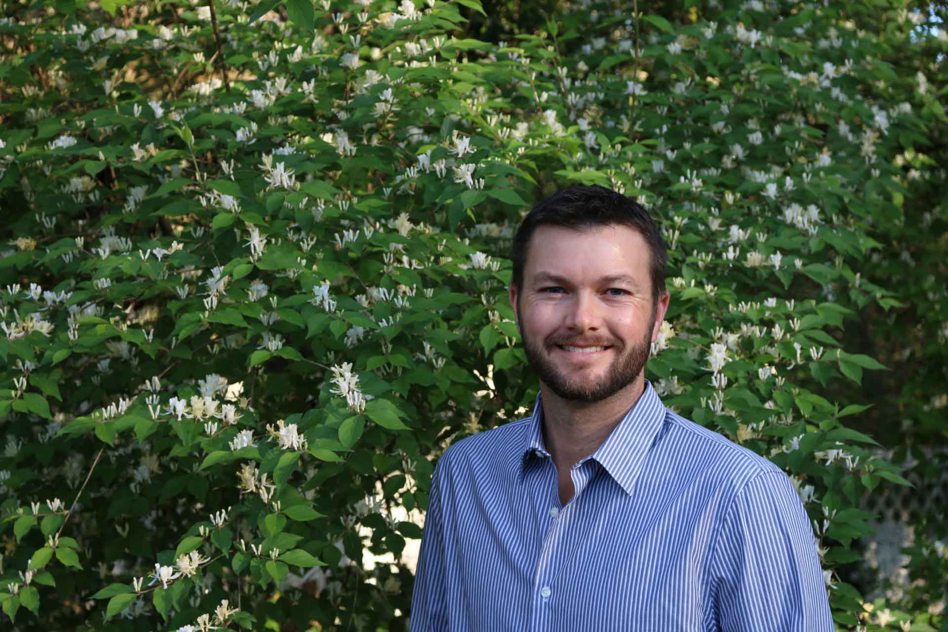 student in front of flowering tree