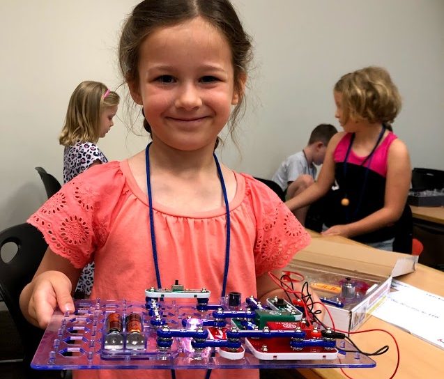 Young girl showing her science project