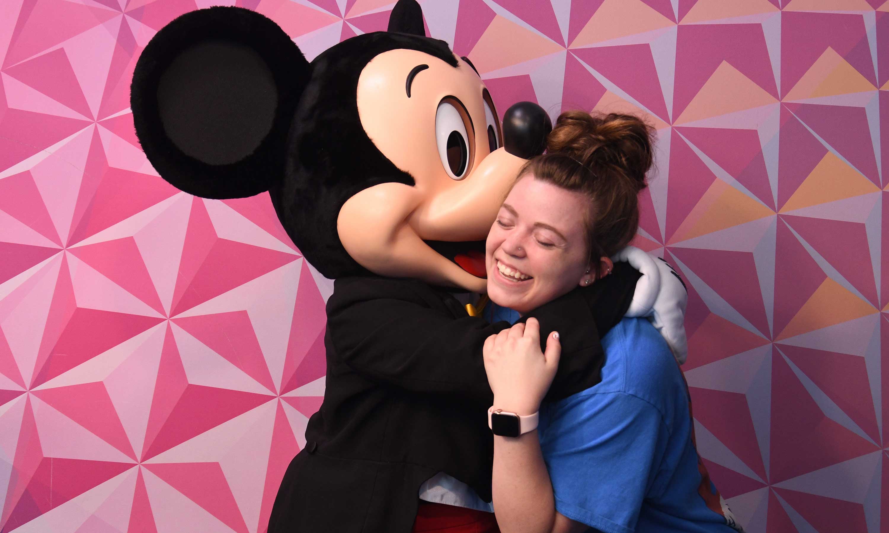 Mickey Mouse hugging student.