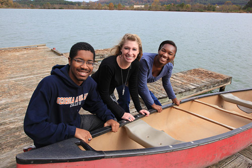 students with boat at the lake